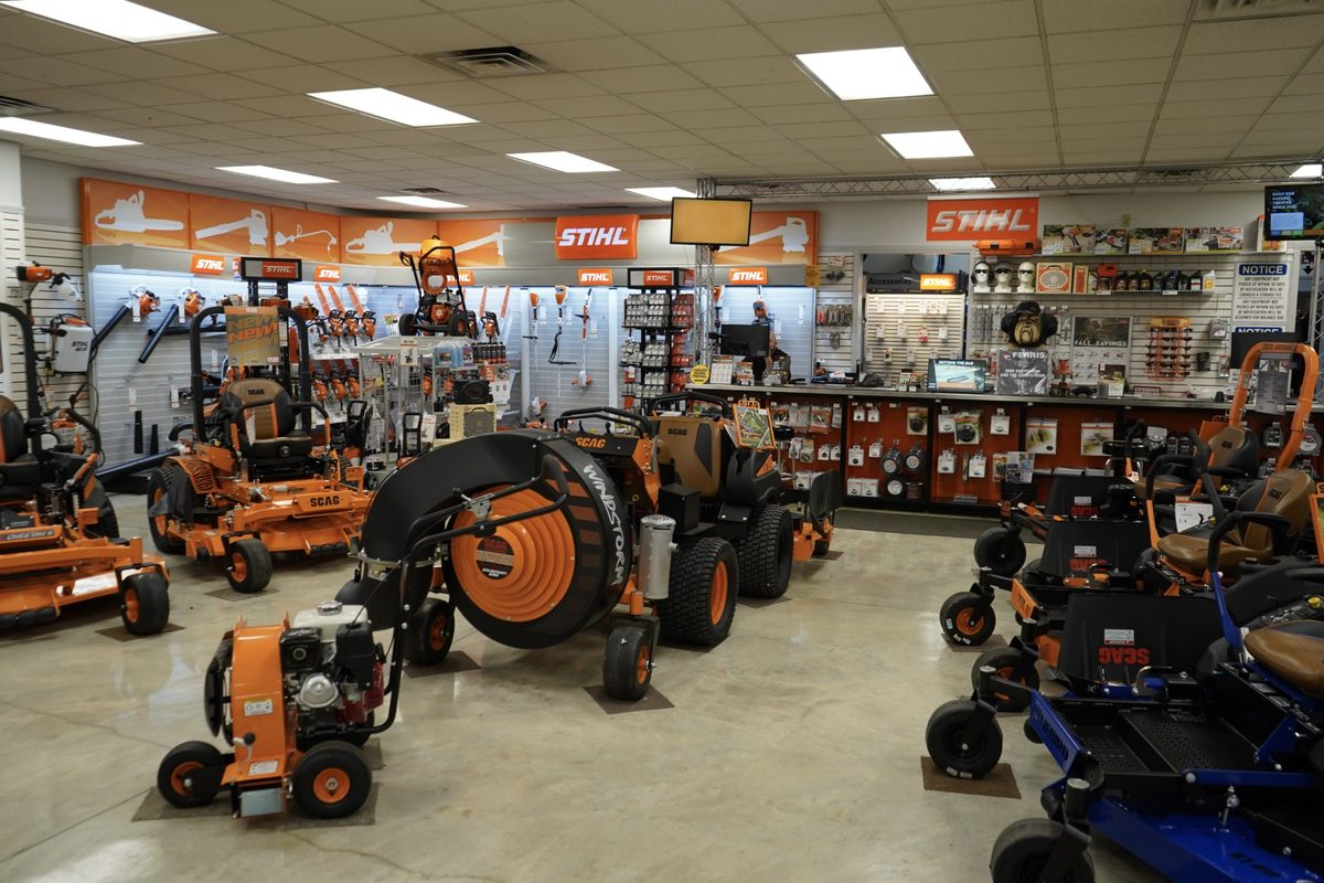 The showroom floor at Industrial Park Distributors, with Scag zero-turn mowers and a wall of STIHL saws and trimmers