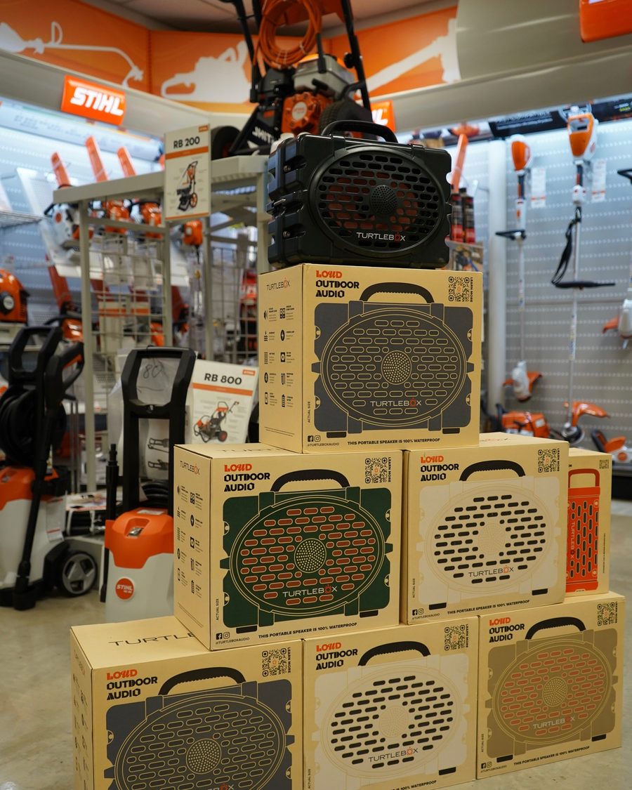 Turtlebox outdoor speakers stacked on the showroom floor beside STIHL equipment